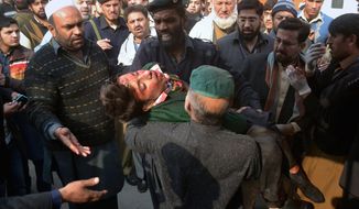 Young targets: Hospital security guards carried out the dead and wounded after the Taliban launched one of the most deadly terrorist attacks ever in Pakistan. Gunmen stormed an army-run school that teaches children in grades one through 10. (Associated Press)