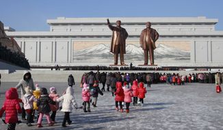 North Koreans gather at the Mansu Hill where the statues of the late leaders Kim Il Sung, and Kim Jong Il tower over them Tuesday, Dec. 16, 2014, in Pyongyang, North Korea, a day before the 3rd anniversary of the death of Kim Jong Il. (AP Photo/Wong Maye-E)