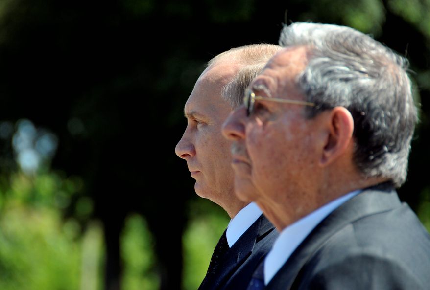 Russia&#39;s President Vladimir Putin (behind) and Cuba&#39;s President Raul Castro attend a ceremony at the Mausoleum of the Soviet Internationalist Soldier in Havana in July during Mr. Putin&#39;s Latin American tour aimed at boosting trade and ties in the region. (Associated Press)