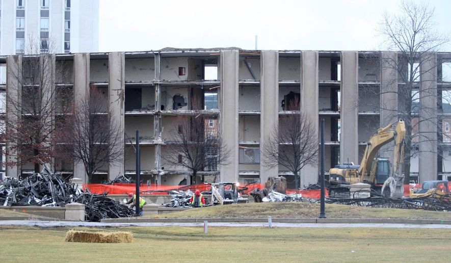 In this Tuesday, Dec. 16, 2014 photo, demolition takes place on the southwest wing of Douglas Hall at Northern Illinois University in DeKalb, Ill. Northern Illinois University is offering a live video feed of the ongoing demolition of the 51-year-old residence hall. The stream offers viewers a wide shot of the scene at Douglas Hall so they can watch equipment and crews working to strategically dismantle the building. (AP Photo/Daily Chronicle, Monica Synett) MANDATORY CREDIT