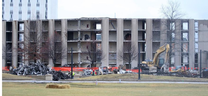 In this Tuesday, Dec. 16, 2014 photo, demolition takes place on the southwest wing of Douglas Hall at Northern Illinois University in DeKalb, Ill. Northern Illinois University is offering a live video feed of the ongoing demolition of the 51-year-old residence hall. The stream offers viewers a wide shot of the scene at Douglas Hall so they can watch equipment and crews working to strategically dismantle the building. (AP Photo/Daily Chronicle, Monica Synett) MANDATORY CREDIT