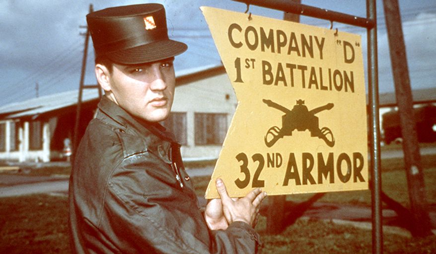 Elvis Presley was inducted into the U.S. Army as a private at Fort Chaffee, near Fort Smith, Arkansas. His arrival was a major media event. Hundreds of people descended on Presley as he stepped from the bus; photographers then accompanied him into the fort.  Presley announced that he was looking forward to his military stint, saying he did not want to be treated any differently from anyone else: &quot;The Army can do anything it wants with me.&quot; Soon after Presley commenced basic training at Fort Hood, Texas, he received a visit from Eddie Fadal, a businessman he had met on tour. According to Fadal, Presley had become convinced his career was finished-&quot;He firmly believed that.&quot; But then, during a two-week leave in early June, Presley recorded five songs in Nashville. In early August, his mother was diagnosed with hepatitis and her condition rapidly worsened. Presley, granted emergency leave to visit her, arrived in Memphis on August 12. Two days later, she died of heart failure, aged 46. Presley was devastated; their relationship had remained extremely close--even into his adulthood, they would use baby talk with each other and Presley would address her with pet names. After training, Presley joined the 3rd Armored Division in Friedberg, Germany, on October 1.  Introduced to amphetamines by a sergeant while on maneuvers, he became &quot;practically evangelical about their benefits&quot; - not only for energy, but for &quot;strength&quot; and weight loss, as well - and many of his friends in the outfit joined him in indulging. The Army also introduced Presley to karate, which he studied seriously, later including it in his live performances.  Fellow soldiers have attested to Presley&#39;s wish to be seen as an able, ordinary soldier, despite his fame, and to his generosity. He donated his Army pay to charity, purchased TV sets for the base, and bought an extra set of fatigues for everyone in his outfit. Elvis Presley is shown in uniform at company D 1st Battalion 32nd U.S. Army Armour at the barr