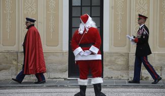 A man dressed as Santa Claus looks at Monaco Chief of staff Luc Fringant, left, and an unidentified Monaco&#x27;s military officer during the traditional Christmas tree viewing and present receiving session at Monaco palace, Wednesday, Dec. 17, 2014. This event takes place every years ahead of Christmas. (AP Photo/Lionel Cironneau)