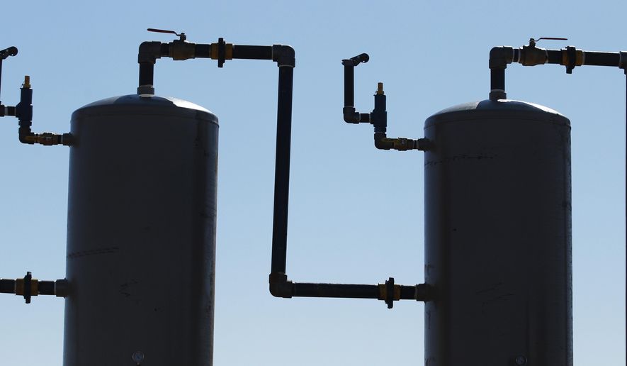 In this Feb. 21, 2012 file photo, oil field equipment silhouetted against the sky near Medicine Lodge, Kan. Plunging crude prices are hitting oil producers especially hard in places like Kansas, where the industry is dominated by smaller, independent operators who depend more heavily on the cash flow from producing wells to pay for drilling new ones. (AP Photo/Orlin Wagner, File)