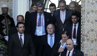 FIFA president Sepp Blatter, center, leaves a hotel to lead a meeting in Marrakech, Morocco, Thursday, Dec. 18, 2014. Amid another crisis at FIFA, Blatter will lead an executive committee meeting on Thursday with the sudden resignation of ethics prosecutor Michael Garcia now on the agenda. (AP Photo/Christophe Ena)