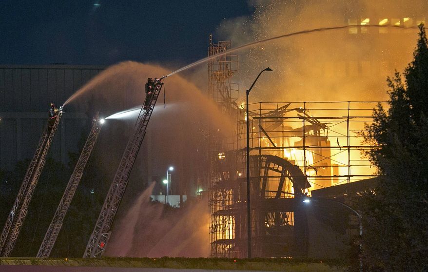 FILE - In this Dec. 8, 2014 file photo, Los Angeles firefighters battle a fire in the seven-story Da Vinci apartment complex under construction in downtown Los Angeles. Investigators have determined that arson caused the massive fire, causing an estimated $20 million to $30 million in damage. The intense heat also melted a freeway sign and cracked or shattered hundreds of windows in nearby office buildings. The Fire Department announced Thursday, Dec. 18, 2014, that the blaze was deliberately set. (AP Photo/Damian Dovarganes, File)