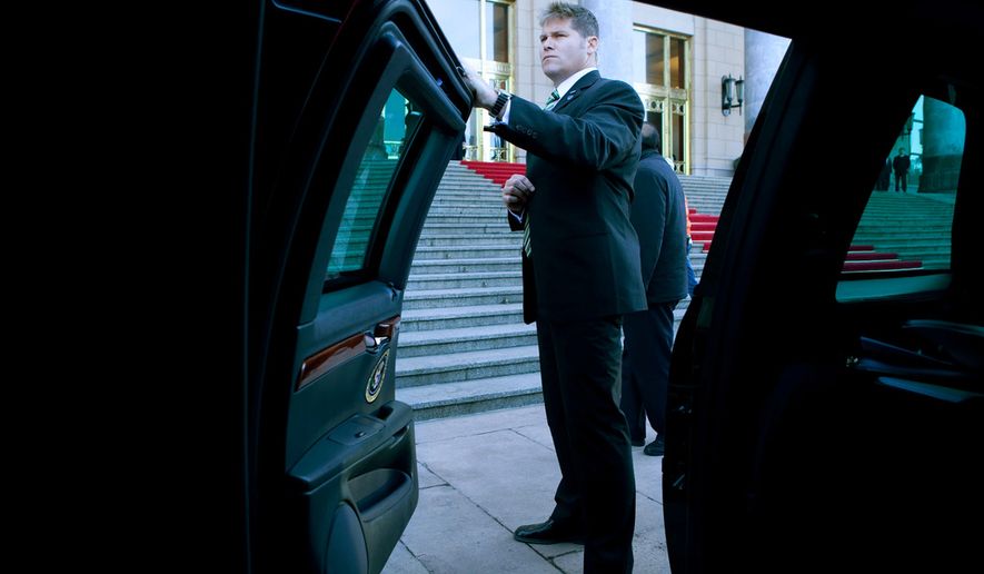 A U.S. Secret Service agent waits by the spare limousine before President Barack Obama&#39;s motorcade departs for a tour of the Forbidden City in Beijing, China, Nov. 17, 2009. (Official White House Photo by Pete Souza)