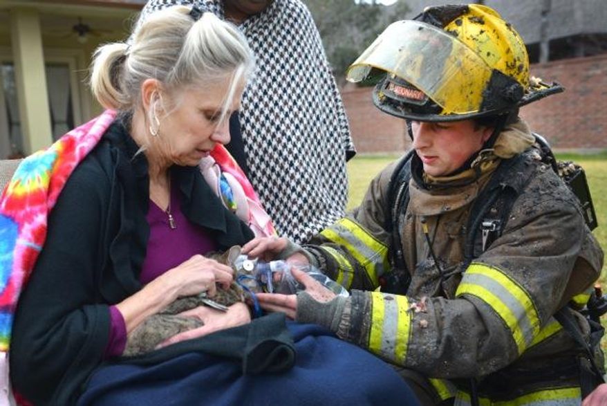 This Dec. 19, 2014 photo provided by the Fort Worth Texas Fire Department shows a firefighter providing oxygen to rescued cat from a house fire in Fort Worth, Texas. The Fort Worth Fire Department announced Saturday, Dec. 20, that the pet, named Stubby, survived. No one was hurt in Friday's fire, which heavily damaged a home. Authorities are trying to determine what sparked the fire. (AP Photo/Fort Worth Texas Fire Dept.)