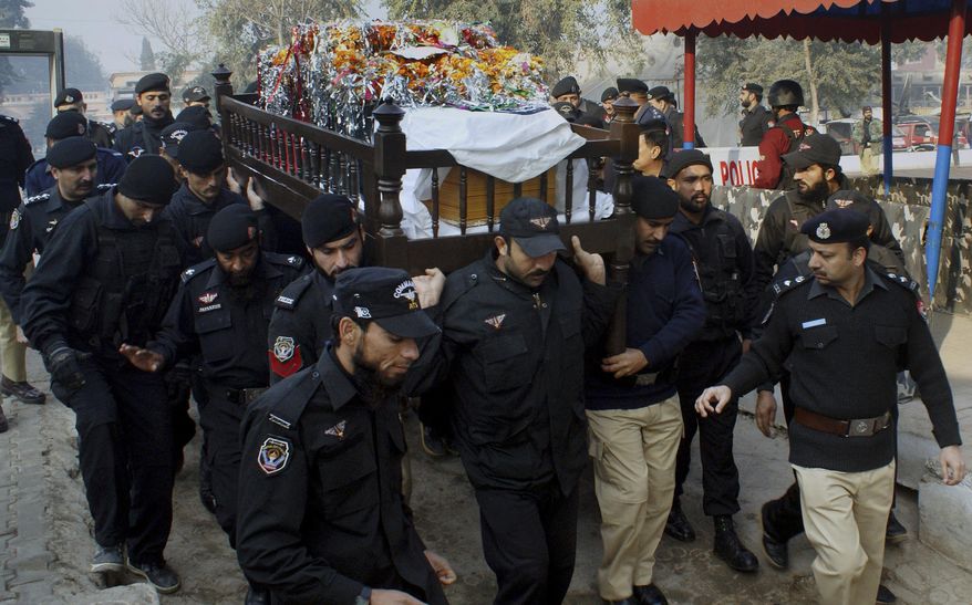 Pakistani police officers carry the casket of their fellow officer killed in the gunbattle with militants, during the funeral procession in Peshawar, Pakistan, Saturday, Dec. 20, 2014. A security official and a police officer were killed during a shootout with militants in Peshawar, police officer Ijaz Ahmed said. He said two militants were killed. (AP Photo/Mohammad Sajjad)