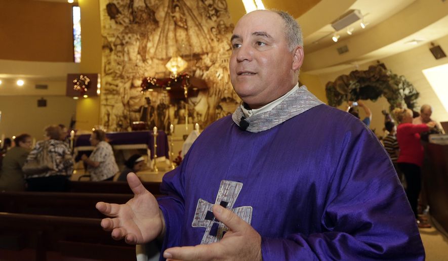 In this photo taken Thursday, Dec. 18, 2014, Rev. Juan Rumin Dominguez talks to a reporter at Our Lady of Charity Catholic church in Miami. Many Catholics have expressed pride in seeing Francis stirring hopes of progress in communist Cuba, but some Cuban-Americans say their spiritual leader betrayed them (AP Photo/Alan Diaz)
