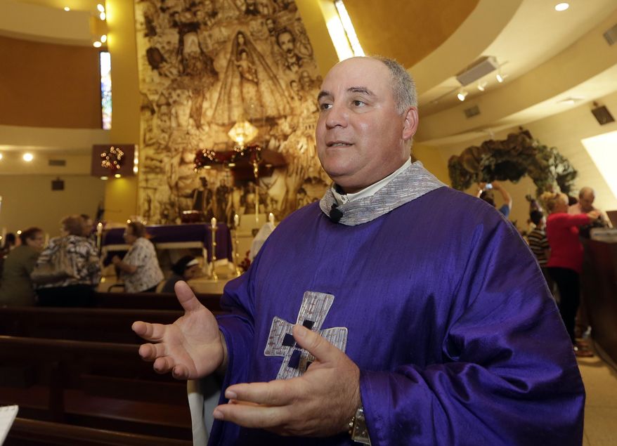 In this photo taken Thursday, Dec. 18, 2014, Rev. Juan Rumin Dominguez talks to a reporter at Our Lady of Charity Catholic church in Miami. Many Catholics have expressed pride in seeing Francis stirring hopes of progress in communist Cuba, but some Cuban-Americans say their spiritual leader betrayed them (AP Photo/Alan Diaz)