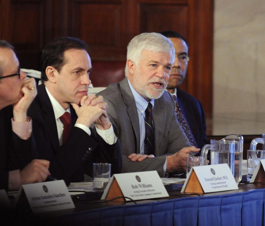 FILE - In this Dec. 17, 2014 file photo, New York environmental conservation commissioner Joseph Martens, right, explains the department's findings on hydraulic fracturing during a cabinet meeting at the Capitol in Albany, N.Y. At left is acting health commissioner Dr. Howard Zucker. Gov. Andrew Cuomo’s administration will move to prohibit fracking in the state. While environmental groups are taking victory laps over the decision some farmers are grieving over lost financial opportunities. (AP Photo/Tim Roske)