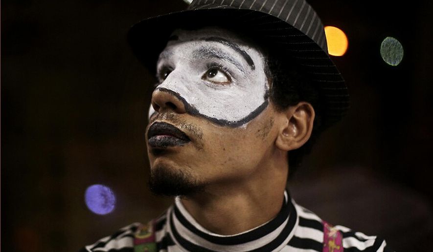 In this Wednesday, Sept. 17, 2014 photo, a 21-year-old Egyptian mime who goes by the name 'Sheetos' performs on a subway in Cairo, Egypt. “I know I look like the strangest thing in their eyes. But I do this to publicize this art. I believe in this art,” said Sheetos. “I try to help people smile during their difficult lives. My wish is to draw smiles on faces.” (AP Photo/Hai Malek)
