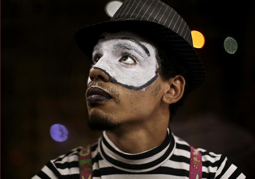 In this Wednesday, Sept. 17, 2014 photo, a 21-year-old Egyptian mime who goes by the name 'Sheetos' performs on a subway in Cairo, Egypt. “I know I look like the strangest thing in their eyes. But I do this to publicize this art. I believe in this art,” said Sheetos. “I try to help people smile during their difficult lives. My wish is to draw smiles on faces.” (AP Photo/Hai Malek)