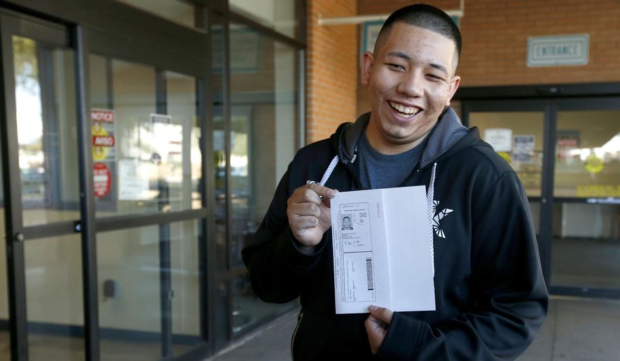 Ramon Maldonado, of Phoenix, smiles as he holds up his new temporary Arizona driver&#x27;s license after passing the required tests as he leaves the Arizona Department of Transportation Motor Vehicle Division office, Monday, Dec. 22, 2014, in Phoenix. Monday marked the first day that about 20,000 immigrants in the country illegally who have received protection from deportation could apply for Arizona licenses. (AP Photo/Ross D. Franklin)