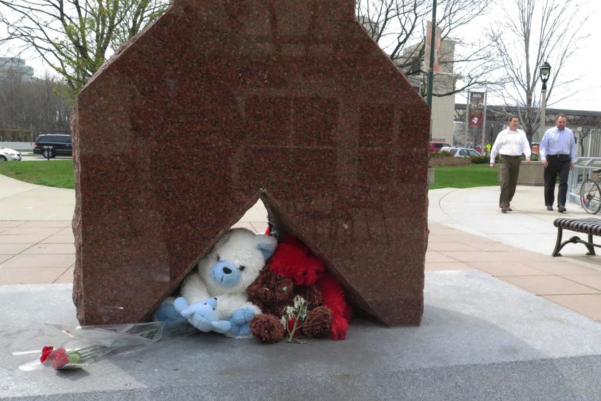 In this May 8, 2014, file photo, flowers and stuffed animals form a makeshift memorial in a Milwaukee park where a white Milwaukee police officer shot and killed a black man. Prosecutors said Monday, Dec. 22, 2014, that Christopher Manney won’t face criminal charges because he shot Dontre Hamilton in self-defense. (AP Photo/Dinesh Ramde, File)