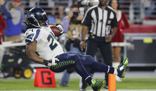 Seattle Seahawks running back Marshawn Lynch (24) leaps into the end zone for a touchdown against the Arizona Cardinals during the second half of an NFL football game, Sunday, Dec. 21, 2014, in Glendale, Ariz. (AP Photo/Rick Scuteri)