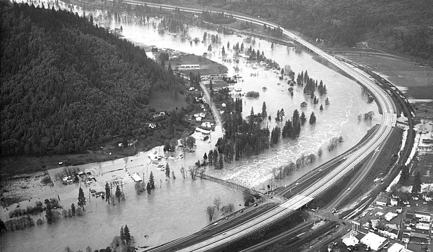 FILE - This Dec. 23, 1964 file photo from the Grants Pass Daily Courier shows the Rogue River flooding the town of Rogue River, Ore. Warm temperatures melting mountain snows combined with heavy rains to push the river out of its banks, cresting at 14 feet above flood stage. (AP Photo/The Grants Pass Daily Courier)