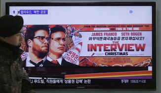 A South Korean army soldier walks near a TV screen showing an advertisement of Sony Picture&#39;s &quot;The Interview,&quot; at the Seoul Railway Station in Seoul, South Korea, Monday, Dec. 22, 2014. (AP Photo/Ahn Young-joon)