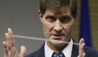 Milwaukee County District Attorney John Chisholm demonstrates bullet trajectory at news conference Monday, Dec. 22, 2014, in Milwaukee. Chisholm announced that there would be no charges against former police office Christopher Manney in the fatal shooting of Dontre Hamilton. (AP Photo/Morry Gash)