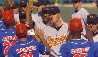 FILE - In this March 28, 1999 file photo, Baltimore Orioles pitcher Mike Timlin, center, and teammates are congratulated by the Cuban national team following the Orioles&#39; 3-2 win in extra innings in Havana, Cuba. The exhibition game was the first time a Major League team has played in Cuba since the Cuban Revolution in 1959. The announcement on Wednesday, Dec. 17, 2014 that the U.S. plans to restore diplomatic ties with the Caribbean nation could usher in a new era in U.S.-Cuba baseball relations, which were strained after the Castro revolution and the U.S.-led economic embargo. (AP Photo/John Moore, File)