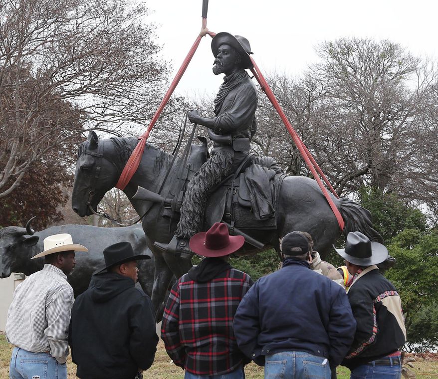 In this Tuesday, Dec. 23, 2014 photo, spectators watch as the last bronze statue, an African-American cowboy, is installed in Indian Spring Park in Waco, Tx. as part of a larger collection of the Chilsom Trail sculptures by artist Robert Summers. Waco workers have installed the final pieces of a bronze tribute to cowboys and cattle, completing an eight-year, $1.65 million project. The Branding the Brazos sculpture project features three cowboys — one white, one Hispanic and one black — and 25 cows, the Waco Tribune-Herald reported. (AP Phot/Waco Tribune Herald, Rod Aydelotte)