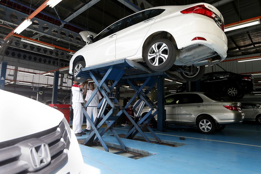 In this photo taken Monday, Dec. 22, 2014, Honda cars are worked on at the service center in Petaling Jaya, Malaysia. Six years ago, Honda began recalling Takata driver’s side air bags in the U.S. because they could inflate with too much force and spew shrapnel into the vehicle. But it wasn’t until last month after a crash in Malaysia that killed a woman and her unborn child that Honda recalled driver’s side air bags in small cars from Asia and Europe. (AP Photo)