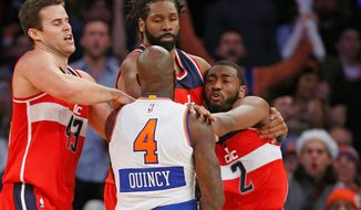 Wizards forwards Kris Humphries (left) and Nene Hilario restrain New York Knicks forward Quincy Acy and Wizards guard John Wall (2) after they engaged in an on-court scuffle in the second half on Thursday at Madison Square Garden. Acy was ejected from the game Wall received a technical foul. (Associated Press Photographs)