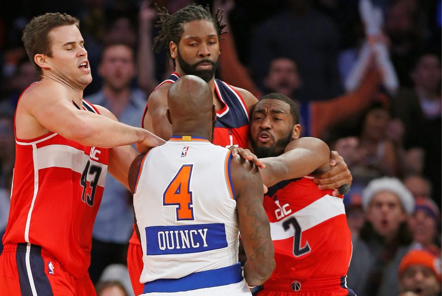 Wizards forwards Kris Humphries (left) and Nene Hilario restrain New York Knicks forward Quincy Acy and Wizards guard John Wall (2) after they engaged in an on-court scuffle in the second half on Thursday at Madison Square Garden. Acy was ejected from the game Wall received a technical foul. (Associated Press Photographs)