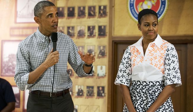 President Barack Obama, with first lady Michelle Obama, speaks to troops and their families on Christmas Day, Thursday, Dec. 25, 2014, at Marine Corps Base Hawaii in Kaneohe Bay, Hawaii during the Obama family vacation. (AP Photo/Jacquelyn Martin)