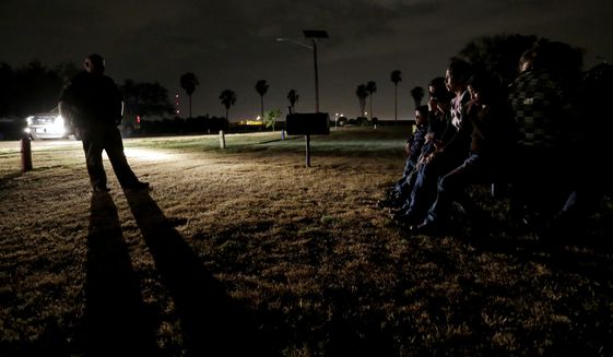 In this June 25, 2014, file photo, a group of immigrants from Honduras and El Salvador, who crossed the U.S.-Mexico border illegally, are stopped in Granjeno, Texas. The Homeland Security Department is experimenting with a new way to track immigrant families caught crossing into the U.S. illegally then released: GPS-enabled ankle bracelets. (AP Photo/Eric Gay, File)