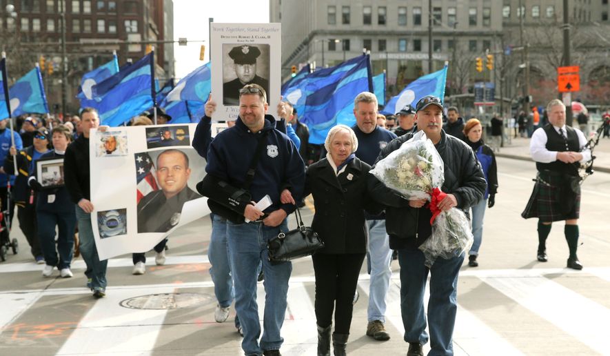 Pat Clark, the mother of slain Cleveland police officer Robert Clark leads marchers from Public Square to the Greater Cleveland Peace Officers Memorial during a "Sea of Blue" rally of support for police officers on Saturday, Dec. 27, 2014, in Cleveland. (AP Photo/The Plain Dealer, Thomas Ondrey ) MANDATORY CREDIT; NO SALES