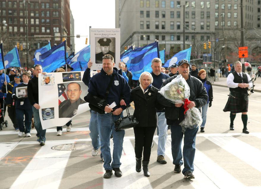 Pat Clark, the mother of slain Cleveland police officer Robert Clark leads marchers from Public Square to the Greater Cleveland Peace Officers Memorial during a "Sea of Blue" rally of support for police officers on Saturday, Dec. 27, 2014, in Cleveland. (AP Photo/The Plain Dealer, Thomas Ondrey ) MANDATORY CREDIT; NO SALES