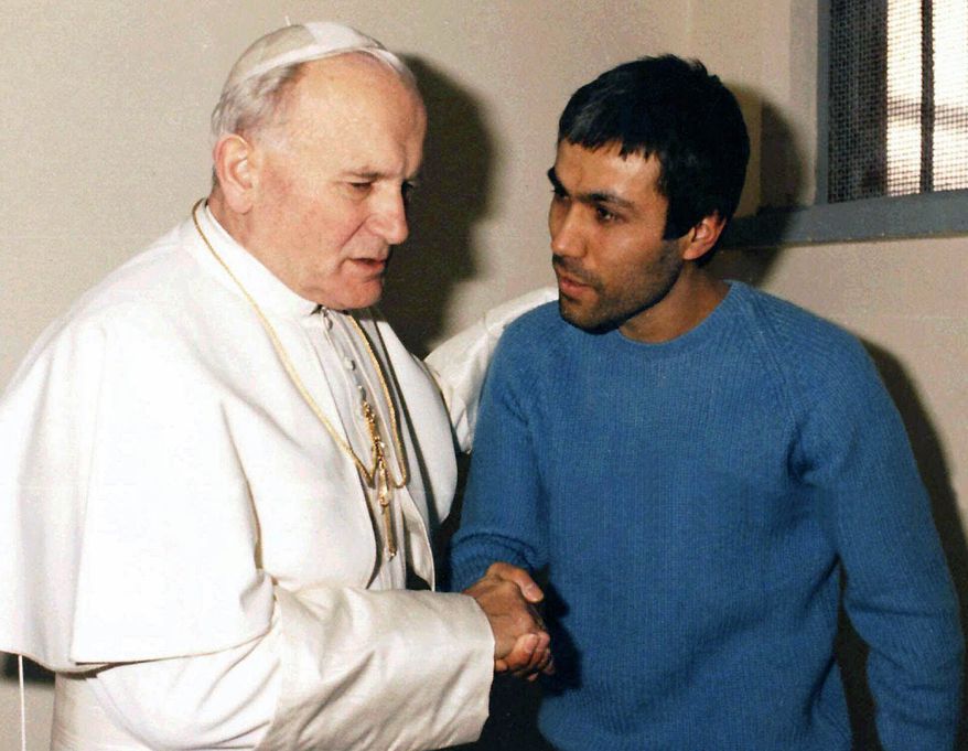 Pope John Paul II, left, meets Mehmet Ali Agca, in Agca's prison cell in Rome, Dec. 27, 1983. The Vatican says the Turk who shot and wounded John Paul II in 1981 has laid flowers on the saint's tomb in St. Peter's Basilica. (Associated Press) ** FILE **