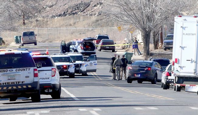 Law enforcement officers from multiple agencies work the scene of a shooting Saturday, Dec. 27 2014 in Flagstaff, Ariz. near where  Flagstaff police officer Tyler Stewart was involved in a fatal shooting. According to the Flagstaff police department Robert W. Smith, 28, of Prescott, Ariz. opened fire on Stewart when he was responding to a domestic violence complaint before taking his own life. (AP Photo/Arizona Daily Sun, Jake Bacon)