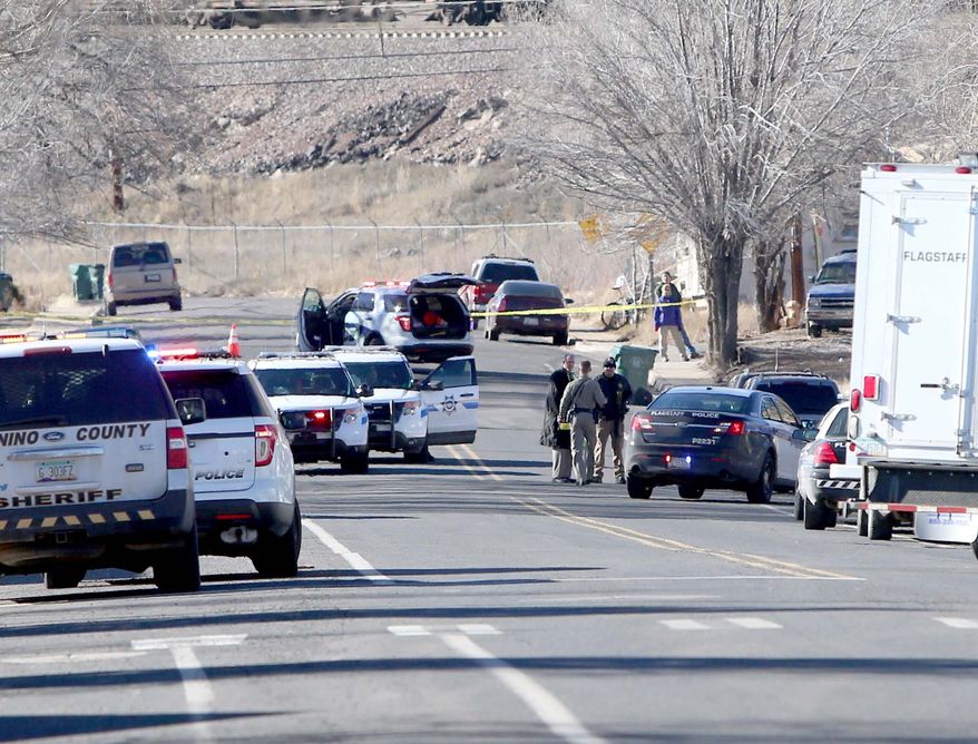 Law enforcement officers from multiple agencies work the scene of a shooting Saturday, Dec. 27 2014 in Flagstaff, Ariz. near where  Flagstaff police officer Tyler Stewart was involved in a fatal shooting. According to the Flagstaff police department Robert W. Smith, 28, of Prescott, Ariz. opened fire on Stewart when he was responding to a domestic violence complaint before taking his own life. (AP Photo/Arizona Daily Sun, Jake Bacon)