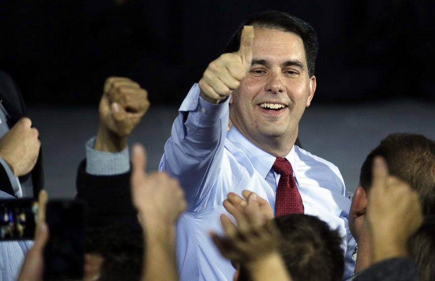 FILE - In this Nov. 4, 2014 file photo, Wisconsin Republican Gov. Scott Walker gives a thumbs-up after speaking at his campaign party, in West Allis, Wis. Walker defeated Democratic gubernatorial challenger Mary Burke. Walker said in an interview Monday, Dec. 29, 2014, that he remains committed to lowering property taxes next year as he promised in his re-election campaign, even though the state faces a projected $2.2 billion state budget shortfall that will likely result in spending cuts and other money-saving moves. (AP Photo/Morry Gash, File)