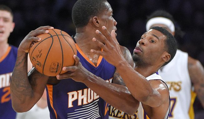 Phoenix Suns guard Eric Bledsoe, left, tries to pass past Los Angeles Lakers guard Ronnie Price during the first half of an NBA basketball game, Sunday, Dec. 28, 2014, in Los Angeles. (AP Photo/Mark J. Terrill)