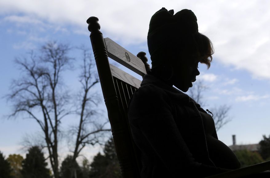 In this Oct. 8, 2014 photo, Violesia, a survivor of sex trafficking, sits on a rocking chair at the faith-based Samaritan Women home in Baltimore. Local and federal law enforcement agencies are trying to do more to combat sex trafficking, but with an ever-increasing volume of survivors being collected, the patchwork of governmental, non-profit and faith-based organizations that provide care are scrambling to keep up. Samaritan Women has the capacity to house, clothe and feed 14 women for up to two years, and the mission to help women re-integrate into society. (AP Photo/Patrick Semansky)