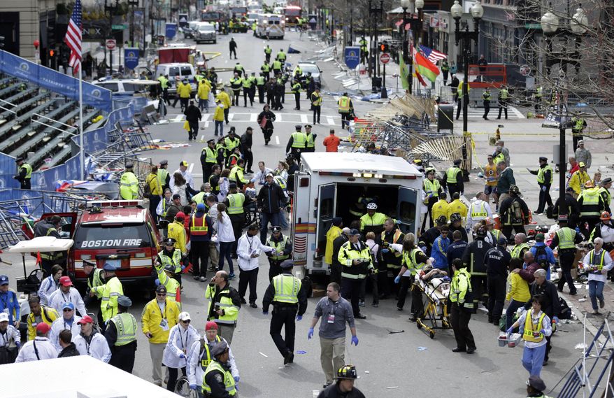 In this April 15, 2013, file photo, medical workers aid injured people at the finish line of the 2013 Boston Marathon following an explosion in Boston. (AP Photo/Charles Krupa, File)