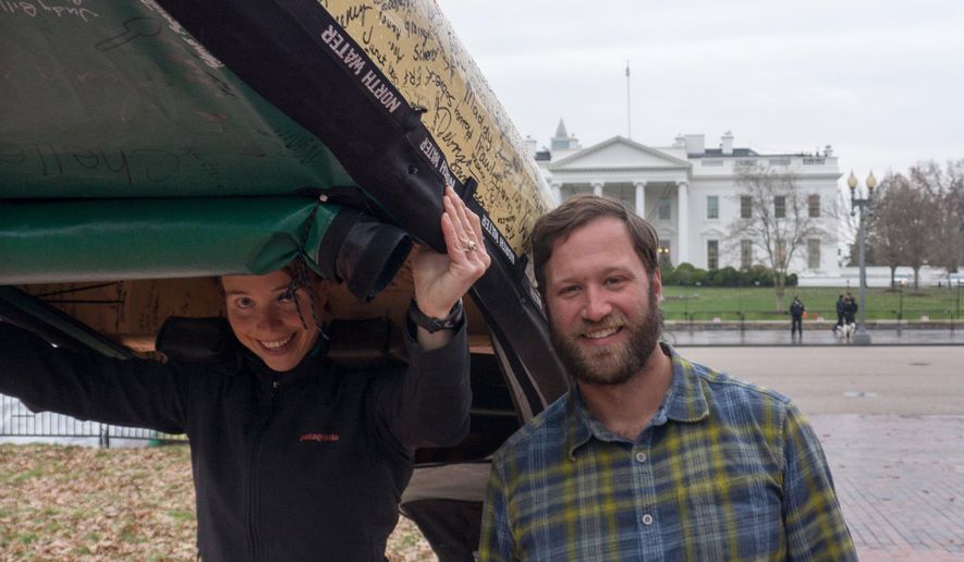 In this Dec. 4, 2014 photo provided by The Wilderness Classroom, Amy and Dave Freeman pose in front of the White House, in Washington, with Sig, the petition canoe they paddled, sailed and portaged more than 2,000 miles from Ely, Minn., because they say their jobs and their way of life are being threatened by a series of copper mines in a sulfide ore body on the edge of the Boundary Waters Canoe Area Wilderness in northern Minnesota. (AP Photo/The Wilderness Classroom, Olivia Ridge)