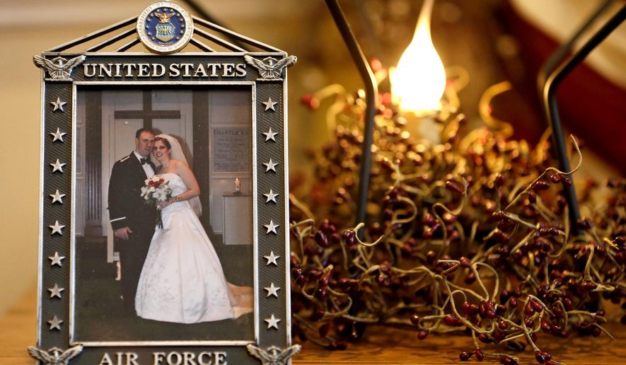 ADVANCE FOR USE MONDAY, JAN. 5, 2015, AND THEREAFTER- This Dec. 16, 2014 photo shows the wedding photo of Army widow, Aimee Wriglesworth, and her late husband, Chad, on display in her home in Bristow, Va. Wriglesworth lost her husband, an Army Major to cancer in 2013. By the hundreds, other widows, widowers, parents, siblings and children are sharing accounts of their grief as part of the largest study ever of America's military families as they go through bereavement. (AP Photo/Steve Helber)