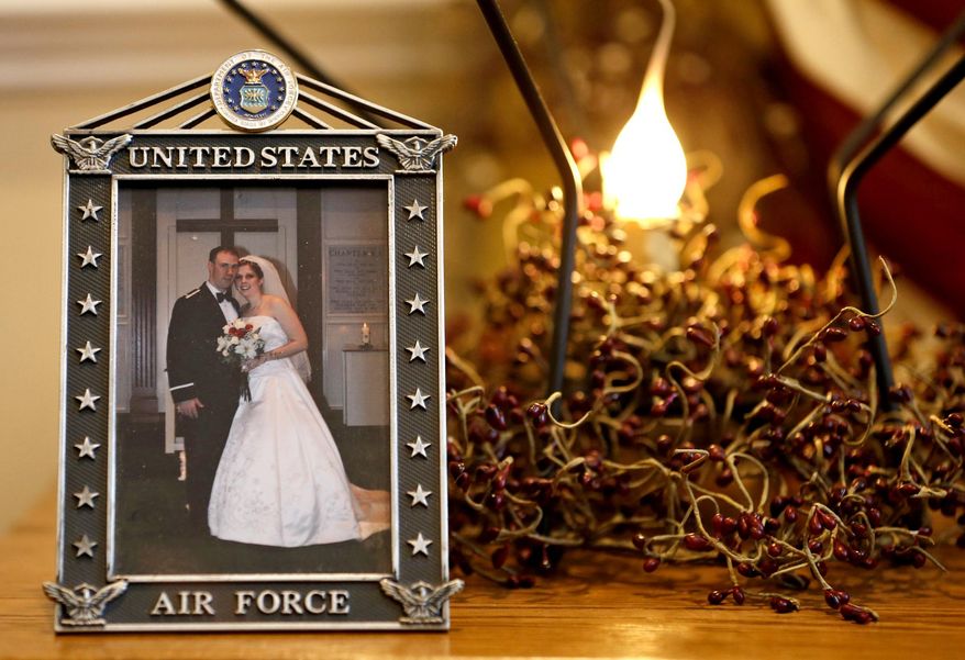 ADVANCE FOR USE MONDAY, JAN. 5, 2015, AND THEREAFTER- This Dec. 16, 2014 photo shows the wedding photo of Army widow, Aimee Wriglesworth, and her late husband, Chad, on display in her home in Bristow, Va. Wriglesworth lost her husband, an Army Major to cancer in 2013. By the hundreds, other widows, widowers, parents, siblings and children are sharing accounts of their grief as part of the largest study ever of America's military families as they go through bereavement. (AP Photo/Steve Helber)