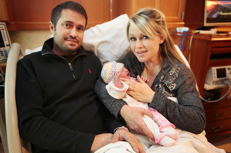 In this Jan. 1, 2015 photo, new parents Kira and Rayburn Gosney sit with their newborn Evelyn Rose Gosney, born at 12:02 am New Years Day, at Mercy Regional Medical Center in Durango, Colo. Evelyn Rose Gosney was the first baby born in the state of Colorado in 2015. (AP Photo/The Durango Herald, Shaun Stanley ) TV OUT
