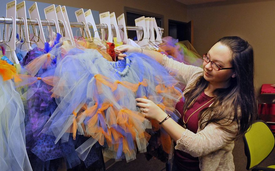 ADVANCE FOR MONDAY JAN. 5 - In this Tuesday, Dec. 23, 2014 photo, costumer and resident designer Angela Sahli shows one of many costumes for the lost girls characters in the GREAT Theatre production of Peter Pan at the theatre production offices in Waite Park, Minn. It's not easy finding the right shade of green for Shrek, making costumes from scratch, or doing fittings for a cast of more than 100 people in two days. But that's what GREAT Theatre costumer/resident designer Angela Sahli does. (AP Photo/The St. Cloud Times, Dave Schwarz) NO SALES