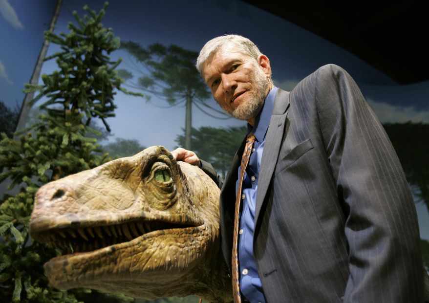 In this May 24, 2007 photo, Ken Ham, founder of the nonprofit ministry Answers in Genesis, poses with one of his favorite animatronic dinosaurs during a tour of the Creation Museum in Petersburg, Ky. A legal battle of biblical proportions could be brewing in Kentucky over the state’s withdrawal of a tax incentive for a religious-themed Noah’s Ark attraction. The Christian ministry building the ark, Answers in Genesis, is challenging the state’s decision to reject a sales tax rebate that could be worth $18 million. (AP Photo/Ed Reinke, File)