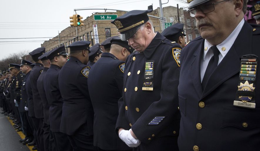 Some police officers turn their backs as Mayor Bill de Blasio speaks during the funeral of New York Police Department Officer Wenjian Liu at Aievoli Funeral Home, Sunday, Jan. 4, 2015, in the Brooklyn borough of New York. Liu and his partner, officer Rafael Ramos, were killed Dec. 20 as they sat in their patrol car on a Brooklyn street. The shooter, Ismaaiyl Brinsley, later killed himself. (AP Photo/John Minchillo)