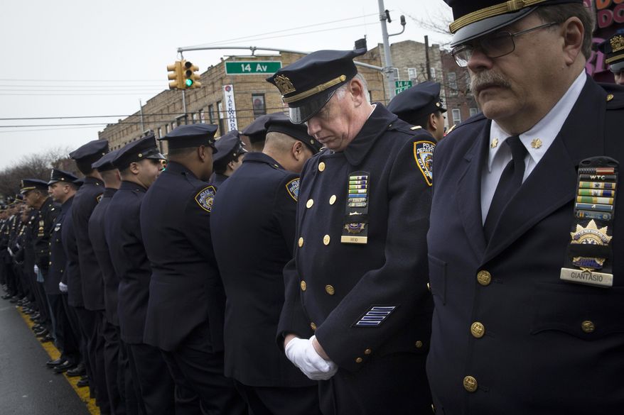 Some police officers turn their backs as Mayor Bill de Blasio speaks during the funeral of New York Police Department Officer Wenjian Liu at Aievoli Funeral Home, Sunday, Jan. 4, 2015, in the Brooklyn borough of New York. Liu and his partner, officer Rafael Ramos, were killed Dec. 20 as they sat in their patrol car on a Brooklyn street. The shooter, Ismaaiyl Brinsley, later killed himself. (AP Photo/John Minchillo)
