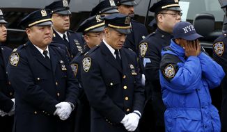 A New York City police officer , right, wipes tears while listening to statements from family members of officer Wenjian Liu during his funeral services at Aievoli Funeral Home, Sunday, Jan. 4, 2015, in the Brooklyn borough of New York. Liu and his partner, officer Rafael Ramos, were killed Dec. 20 as they sat in their patrol car on a Brooklyn street. The shooter, Ismaaiyl Brinsley, later killed himself. (AP Photo/Julio Cortez)