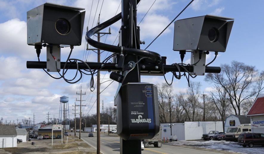 FILE - This Tuesday, Feb. 25, 2014, file photo, shows speed cameras aimed at U.S. Route 127 in New Miami, Ohio. One of the early users of traffic camera enforcement in Ohio announced Monday, Jan. 5, 2015, it will stop using fixed-position cameras because of a new state law. Dayton has used camera enforcement for more than a decade, but city police spokeswoman Cara Zinski-Neace said budgetary considerations led to the decision to curtail their use when the Ohio law takes effect in March. The law passed last month regulates statewide use of the devices and requires that a police officer be present for camera-issued citations. (AP Photo/Al Behrman, File)